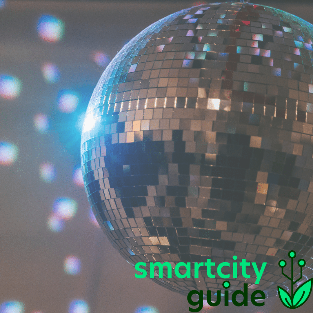Spiegelkugel reflektiert Lichtpunkte, darüber ein blaues Licht, mit Logo "smartcity guide" in der Ecke.