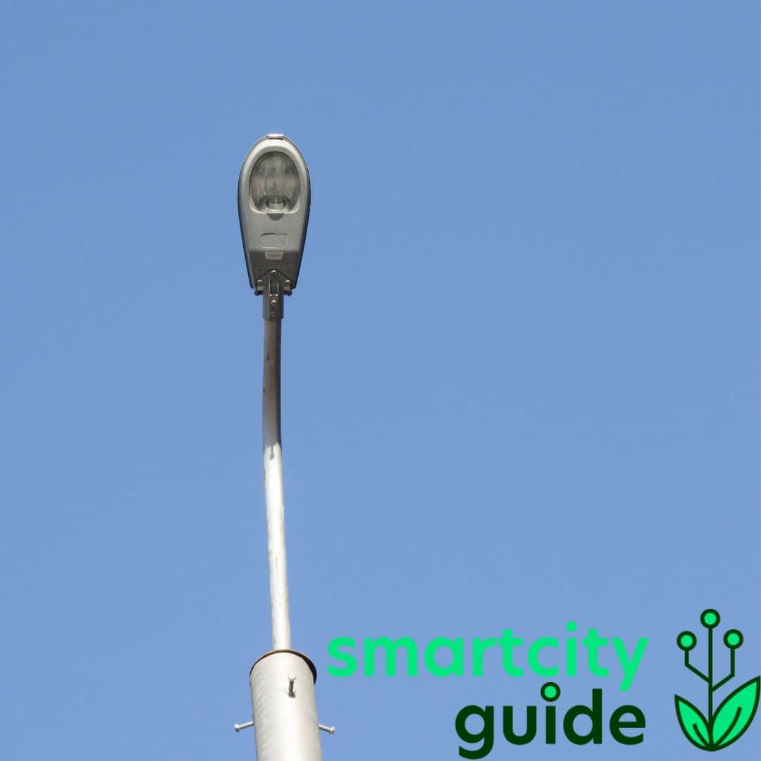 Straßenlaterne vor blauem Himmel, mit "smartcity guide" Logo im unteren rechten Bildbereich.